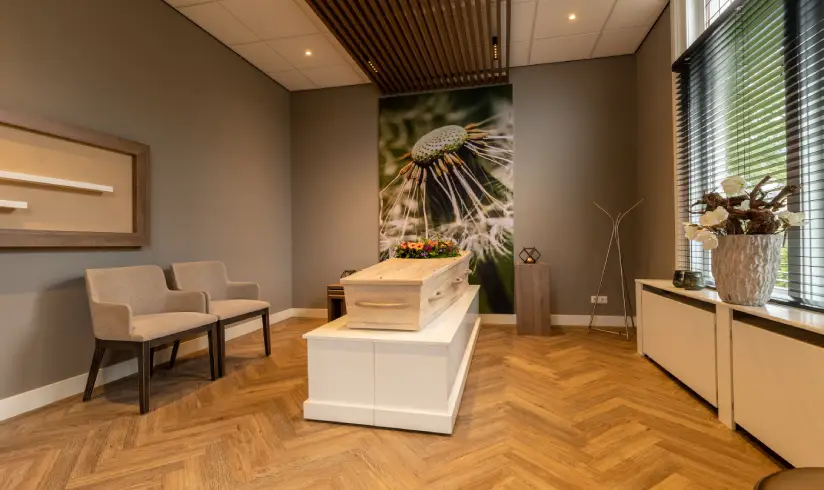Opbaarkamer met kist en de zithoek met stoelen en banken